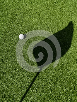 Golf ball on the green, shadow of a flagÃÂ on a green,ÃÂ golf course photo